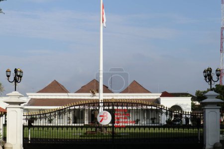 Téléchargez les photos : Yogyakarta, Indonésie - 9 juillet 2023 - Vue de face du palais Gedung Agung Yogyakarta ou Yogyakarta, avec le drapeau indonésien flottant haut sur le mât. - en image libre de droit