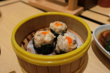Chicken dimsum served in bamboo plate. Dimsum is a large range of small dishes that Cantonese people traditionally enjoy in restaurants for breakfast and lunch.
