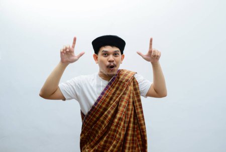 asiatischer muslimischer Mann mit Sarong, der etwas mit seinen Händen zeigt