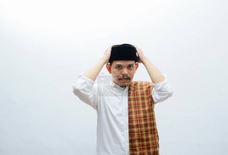 asian muslim man standing pose touching his cap