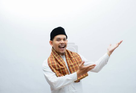 asian muslim man wearing sarung pointing something with his hands