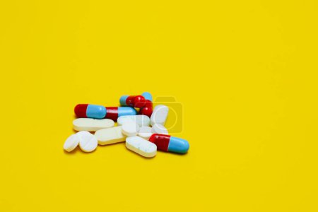 Photo for Photo of medicine capsules and tablets isolated on yellow background - Royalty Free Image