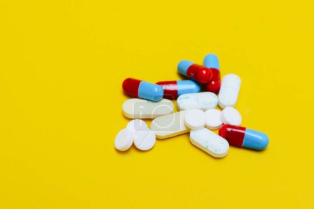 Photo for Photo of medicine capsules and tablets isolated on yellow background - Royalty Free Image