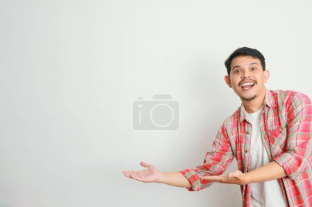 un hombre asiático sonríe y señala algo con su mano