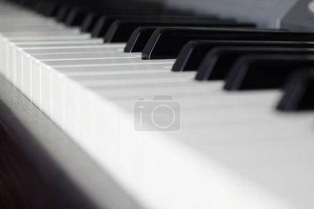 Detail der schwarz-weißen Tasten einer Klaviertastatur, in der eine davon herausragt