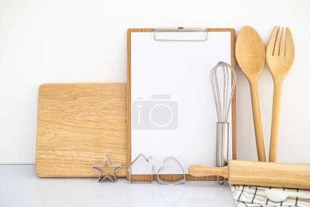 Foto de Libro y utensilios de cocina de recetas vintage en blanco. Vista frontal con espacio de copia - Imagen libre de derechos