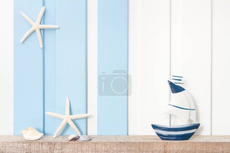 Foto de Fondo de decoración del mar de verano - Vista frontal de velero, estrella de mar y concha en estante de madera sobre pared blanca azul . - Imagen libre de derechos