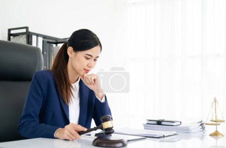 Foto de Abogada en oficina moderna con escala de latón y mazo en mesa blanca. justicia y derecho - Imagen libre de derechos