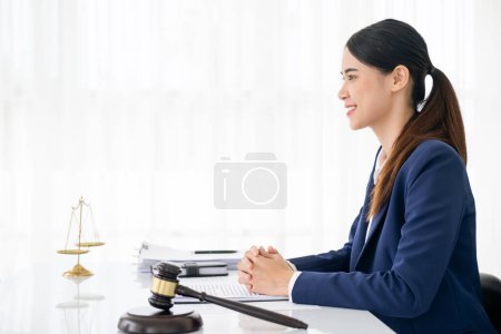 Foto de Abogada en oficina moderna con escala de latón y mazo en mesa blanca. justicia y derecho - Imagen libre de derechos