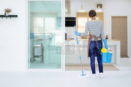 Photo for Young woman preparing to clean the kitchen. Standing back - Royalty Free Image