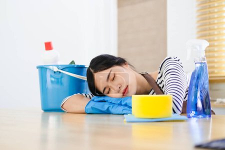 Foto de Mujer cansada y agotada limpiando la casa en la sala de cocina, frustrada con hacer mucho trabajo sobre la casa descansando durante un minuto después de terminar el trabajo, tomando un descanso - Imagen libre de derechos