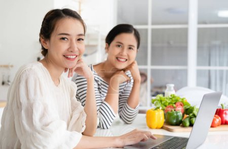 Foto de Las mujeres asiáticas preparan ingredientes para cocinar seguir curso de cocina en línea en el sitio web a través de tabletas. contenido de cocina en la tecnología de Internet para el concepto de estilo de vida moderno - Imagen libre de derechos