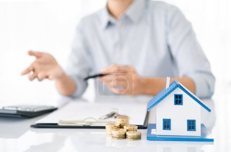 agentes de bienes raíces hablan de alquilar o comprar una casa en la oficina.