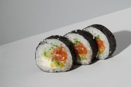 Foto de Rodar sobre un fondo gris claro. Para anunciar la entrega de sushi. - Imagen libre de derechos