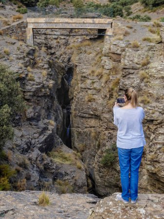 Photo for Young woman contemplating from a beautiful viewpoint the mountains of the Alpujarra of Granada in Andalusia - Royalty Free Image