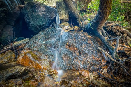 Long exposure photo of a small waterfall in a stream