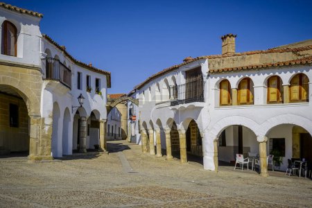 Stone arches with whitewashed walls in the main square of the Cceres town of Garrovillas de Alconetar