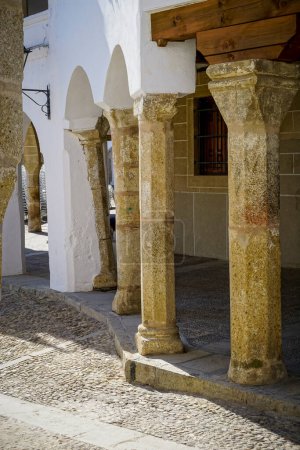 Stone arches with whitewashed walls in the main square of the Cceres town of Garrovillas de Alconetar