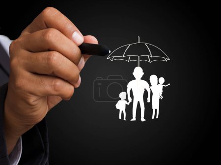 Mann zeigt durch den Stift auf das Familiensymbol unter dem Regenschirm, Geschäfts-, Bank- und Versicherungskunst