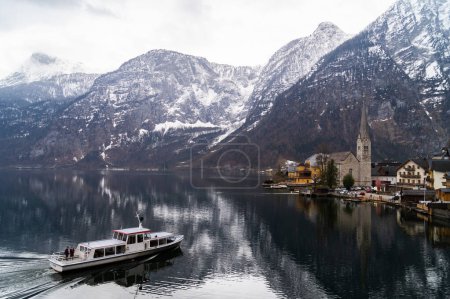 Photo for Boat transporting people in Austrian town Hallstatt. - Royalty Free Image