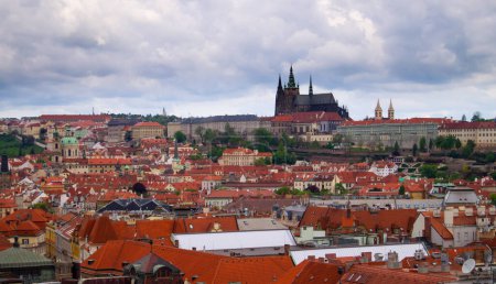 Cityscape of Prague, Czechia. Old Europe, red roofs, cloudy day, historical cityscape. Church in the background. Prague castle. 