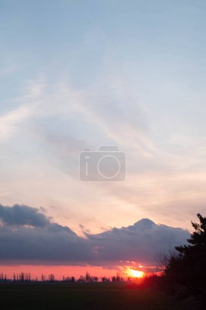 Photo for Breathtaking sunrise painting the sky with vivid colors over a pastoral landscape, inspiring awe. Dramatic sky as daybreak unfurls with radiant colors. Morning glory over farmland. - Royalty Free Image