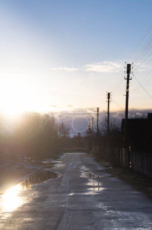 La luz de la noche baña una tranquila carretera de la ciudad ucraniana, que refleja el final del día. Sunset road en Ucrania; ambiente tranquilo como transiciones del día a la noche. Pequeña ciudad serenidad capturada al atardecer en una tranquila calle ucraniana.