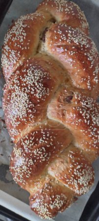 Freshly baked Ukrainian sweet bread with a delightful chocolate filling, topped with sesame seeds for a crisp finish, captured in all its homemade glory.