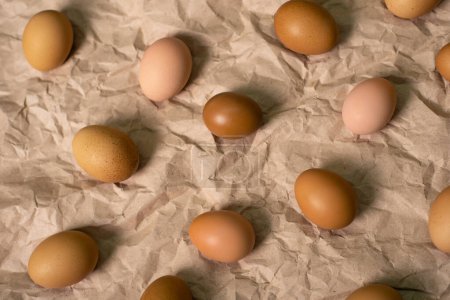 Huevos de pollo marrón en el fondo de papel marrón arrugado.