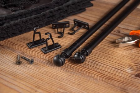 Black accessories for curtains on a wooden table. Black fittings