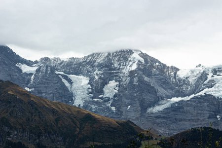 Photo for Snowy Alp mountains in the Switzerland. Beautiful view on snow-covered mountain peaks. Autumn in Murren. Cloudy sky - Royalty Free Image