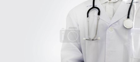 Téléchargez les photos : Un médecin à moitié debout, sans visage, tenant un stéthoscope sur un fond blanc. - en image libre de droit