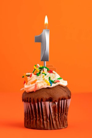 Téléchargez les photos : Bougie numéro 1 - Gâteau anniversaire en fond orange - en image libre de droit