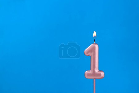 Téléchargez les photos : Numéro 1 - Bougie d'anniversaire brûlante sur fond mousseux bleu - en image libre de droit