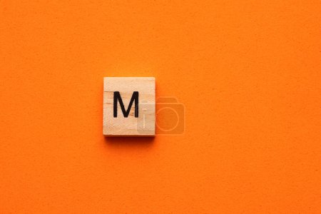 Téléchargez les photos : Alphabet lettre M sur tuile carrée en bois - Orange fond mousseux - en image libre de droit