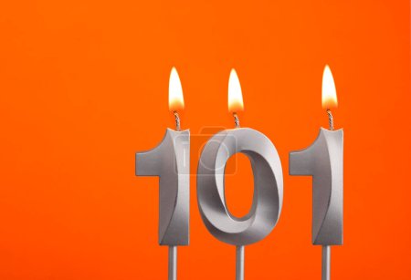 Téléchargez les photos : Bougie 101 - Bougie d'anniversaire en argent sur fond orange - en image libre de droit