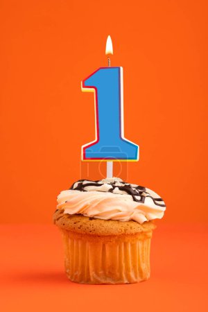 Téléchargez les photos : Bougie bleue numéro 1 gâteau d'anniversaire sur fond orange. - en image libre de droit