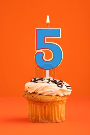 Foto de Azul número 5 vela - Pastel de cumpleaños sobre fondo naranja. - Imagen libre de derechos