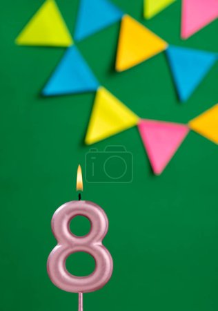 Foto de Vela de cumpleaños número 8 - Celebración del aniversario en fondo de color verde - Imagen libre de derechos