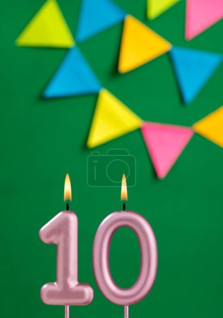 Foto de Vela de cumpleaños número 10 - Celebración del aniversario en fondo de color verde - Imagen libre de derechos