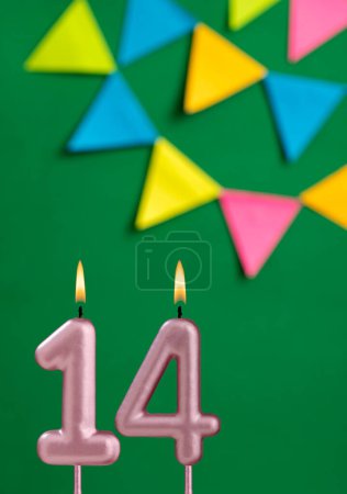 Foto de Número 14 vela de cumpleaños - Celebración del aniversario en fondo de color verde - Imagen libre de derechos