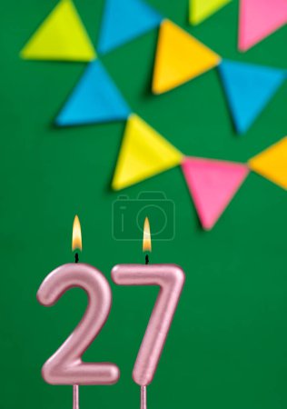 Foto de Número 27 vela - Celebración de cumpleaños sobre fondo verde - Imagen libre de derechos