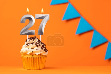Foto de Vela número 27 - Cumpleaños de pastel en fondo naranja - Imagen libre de derechos