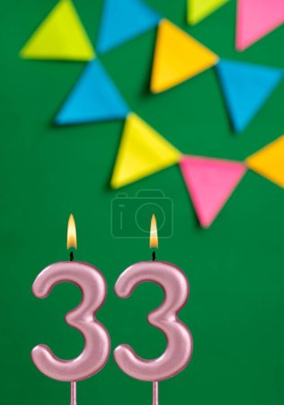 Foto de Número 33 vela - Celebración de cumpleaños sobre fondo verde - Imagen libre de derechos