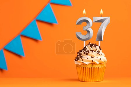 Foto de Vela número 37 - Cumpleaños de pastel en fondo naranja - Imagen libre de derechos