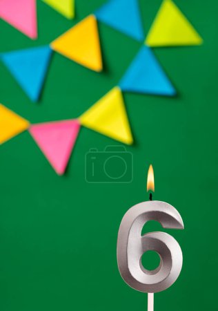 Foto de Tarjeta de cumpleaños vertical con número 6 vela Fondo verde con banderines - Imagen libre de derechos