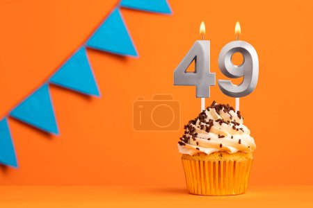 Foto de Vela número 49 - Cumpleaños de pastel en fondo naranja - Imagen libre de derechos