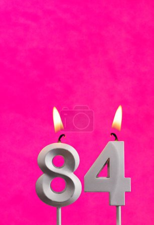 Photo for Candle 84 with flame - Birthday card in fuchsia background - Royalty Free Image