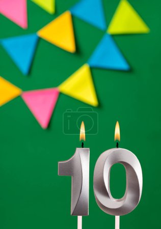 Foto de Tarjeta de cumpleaños vertical con número 10 vela Fondo verde con banderines - Imagen libre de derechos