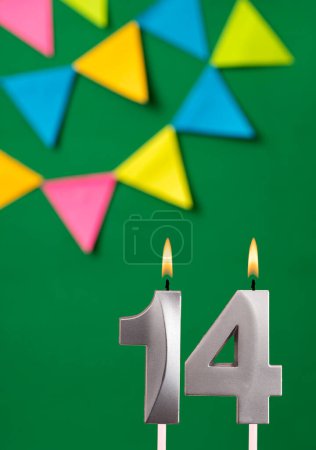 Foto de Tarjeta de cumpleaños vertical con número 14 vela Fondo verde con banderines - Imagen libre de derechos
